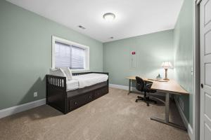 a bedroom with a bed and a desk and a window at Casa Roja in Edina