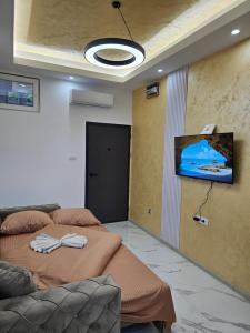 Ein Zimmer mit zwei Betten und einem Fernseher an der Wand. in der Unterkunft Studio centar Lazic 2 in Šid