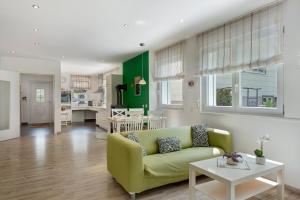 a living room with a green couch and a table at Ferienwohnung Paffendorf in Gutach