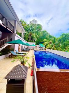 a swimming pool in front of a building with trees at Cerf Island Resort in Cerf Island