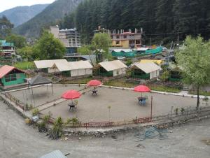 an aerial view of a town with red umbrellas at Chaman Vatika in Kasol