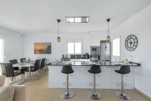 a kitchen and dining room with a counter and chairs at Casa Karlsen in Ciudad Quesada