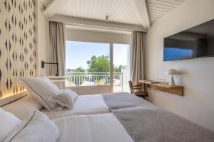 a bedroom with a large white bed and a window at Hoposa Panorama in Port de Pollensa +24 photos