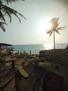 a palm tree on a beach with the ocean at NEW BEACH HOTEL Anjuna in Anjuna