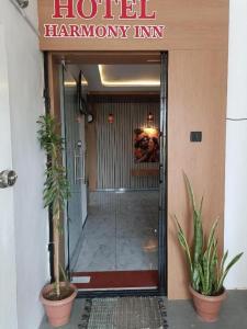 a hotel hallway with plants in front of a building at Hotel Harmony Inn in Ahmedabad