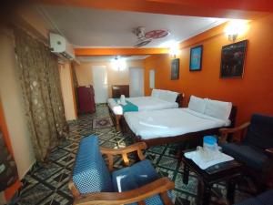 a room with two beds and chairs in it at NEW BEACH HOTEL Anjuna in Anjuna