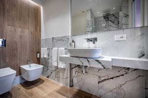 ein Badezimmer mit Waschbecken und Toilette in der Unterkunft Hotel Emma Small Luxury Hotel in Florenz