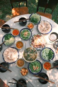 a table with many plates of food on it at De Hué in Hue +62 photos