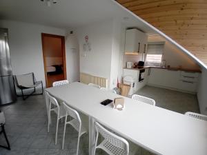 a room with a table and chairs and a kitchen at Bükfürdő Bercsényi 13 apartmanház, Bükfalva in Bük +12 photos