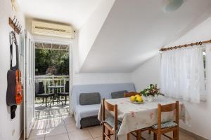 a dining room with a table and chairs and a guitar at Guest House Matana Pomena in Pomena