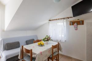 a dining room with a table and a couch at Guest House Matana Pomena in Pomena