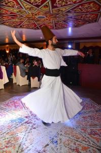 a man in a white dress dancing on a dance floor at BOSPHOROUS DİNNER CRUISe in Istanbul