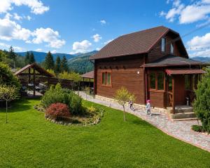 a house with two children walking in front of it at GSpace in Yaremche