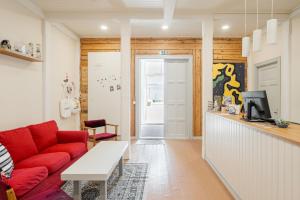 a living room with a red couch and a tv at FolkiaCenter Gästhem - Vieraskoti - Guesthouse in Hanko