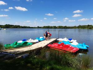 a group of boats parked at a dock on a lake at Camping 3 étoiles - ccbfige in Pouancé