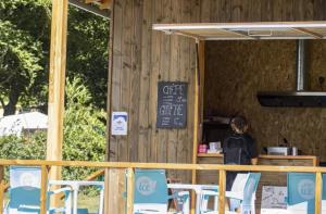 a woman sitting at a counter in a restaurant at Camping 3 étoiles - ccbfige in Pouancé