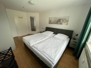 a bedroom with a bed with white sheets at Ostseetraum Usedom in Zempin