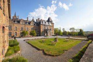 a large building with a park in front of it at Domaine de Ronchinne in Maillen