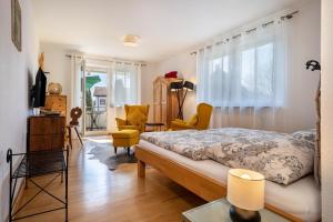 a bedroom with a bed and chairs in a room at Haus Grete in Langenargen