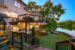 a large house with a deck and a lake at Lakefront Group Stay, Sleeps 19, Indoor Pool, Hot Tub, Arcades in Terre Haute