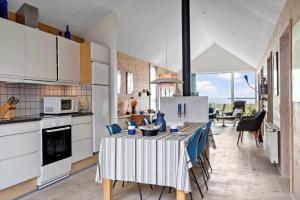 a kitchen with a table and a kitchen with white cabinets at 746-Hvide-Sande-Slusen-46 in Hvide Sande
