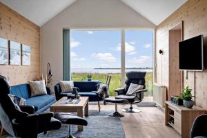 a living room with a blue couch and chairs and a large window at 746-Hvide-Sande-Slusen-46 in Hvide Sande