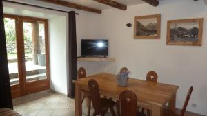 uma sala de jantar com uma mesa de madeira e uma televisão em Mon petit Chalet em Valmeinier