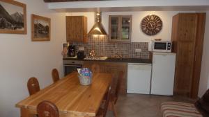 a kitchen with a wooden table and a microwave at Mon petit Chalet in Valmeinier