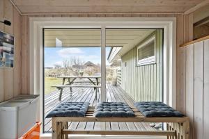 a large sliding glass door to a deck with a bench at 358-Hvide-Sande-Fyrmarken-25 in Hvide Sande