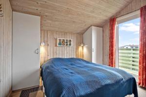 a bedroom with a bed and a large window at 358-Hvide-Sande-Fyrmarken-25 in Hvide Sande