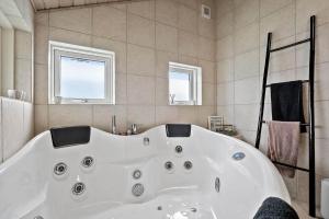 a large white bath tub in a bathroom at 358-Hvide-Sande-Fyrmarken-25 in Hvide Sande +41 photos