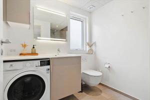 a bathroom with a washing machine and a toilet at 9952-Hvide-Sande-Langsand-204 in Hvide Sande +29 photos