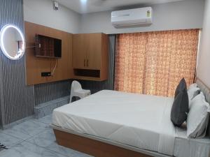 a bedroom with a white bed and a window at Hotel Harmony Inn in Ahmedabad