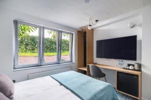 a hotel room with a bed and a flat screen tv at Grand Tulipan in Gdynia