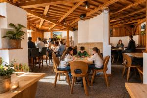 a group of people sitting at a table in a restaurant at Alpinchalet Zigjam in Gaschurn