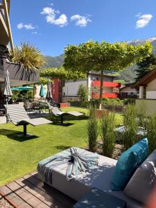 a garden with a couch and benches on a lawn at Genusshotel Diamant in Naturno