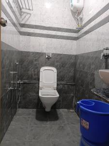 a bathroom with a toilet and a sink at Hotel Harmony Inn in Ahmedabad