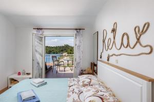 a bedroom with a bed with a relax sign on the wall at Guest House Matana Pomena in Pomena +135 photos