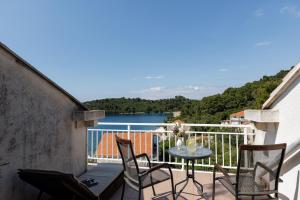a balcony with a table and chairs and a view of a lake at Guest House Matana Pomena in Pomena