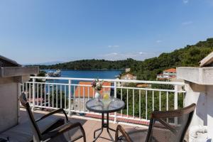 a table on a balcony with a view of the water at Guest House Matana Pomena in Pomena