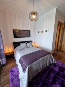a bedroom with a large bed with a purple rug at Sol e Luna in Ponta