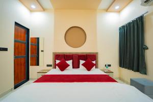 a bedroom with a large white bed with red pillows at Hotel Galaxy 700 - A Luxury Hotel Near KhatuShyamJi Temple in Khātu