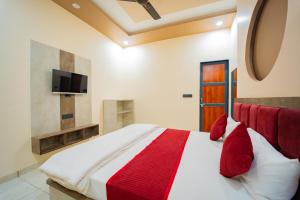 a bedroom with a large bed with red pillows at Hotel Galaxy 700 - A Luxury Hotel Near KhatuShyamJi Temple in Khātu
