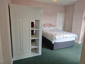 a bedroom with a bed and a white cabinet at St Peters Avenue in Cleethorpes