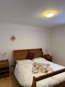a bedroom with a large bed with white sheets at Max 's Siusi Apartament in Siusi