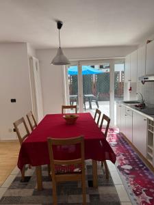 a kitchen and dining room with a red table and chairs at Max 's Siusi Apartament in Siusi