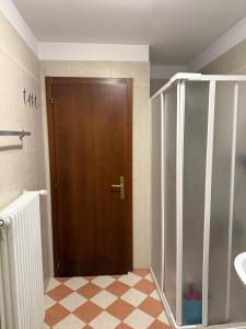 a bathroom with a brown door and a tiled floor at Max 's Siusi Apartament in Siusi +26 photos