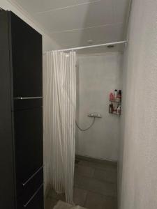 a bathroom with a shower with a shower curtain at Small and cozy room in Kalundborg