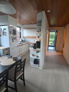 a kitchen with a dining table and a refrigerator at Small and cozy room in Kalundborg