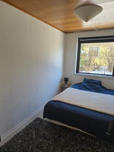 a bedroom with a bed and a window at Small and cozy room in Kalundborg